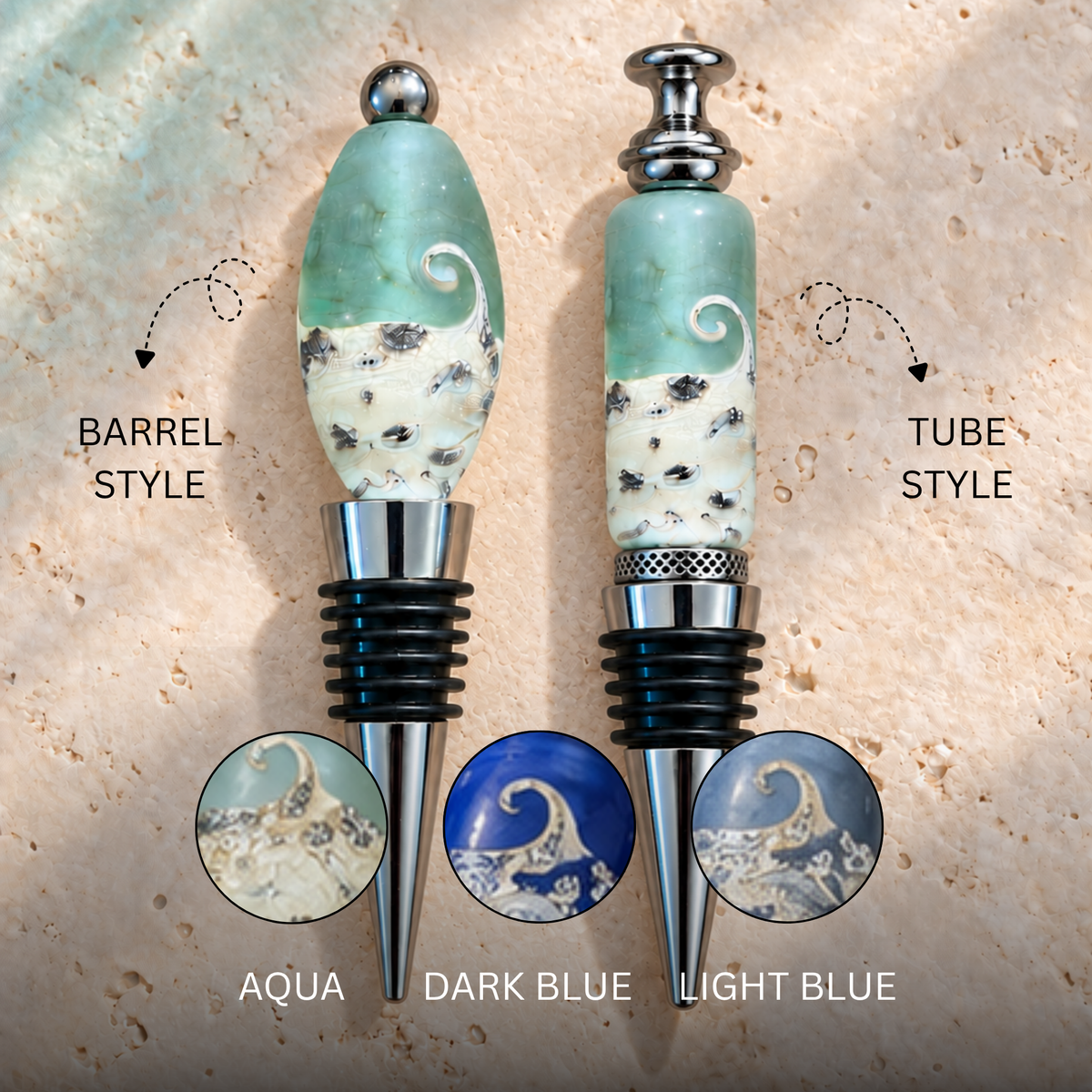 Two bottle stoppers shown on a stone-like beige background, labeled Barrel Style and Tube Style, with circular insets showing aqua, dark blue, and light blue wave designs. The stoppers have sculpted wave-patterned handles in aqua, cream, and dark blue, with silver metal collars and black rubber grommets.